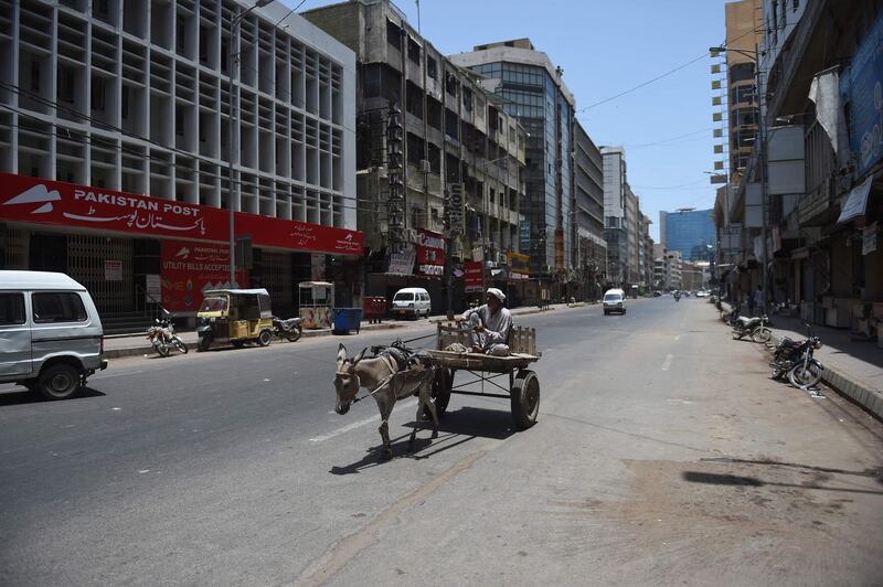 A man rides his donkey cart in a deserted street after the authorities sealed most of the area of Karachi. AFP