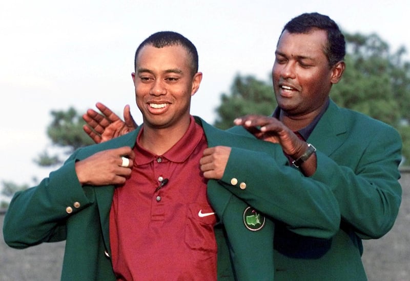 Tiger Woods (L) of the US gets his second green jacket from 2000 Masters Champion Vijay Singh (R) of Fiji 08 April, 2001 after the final round of the 2001 Masters Golf Tournament at the Augusta National Golf Club in Augusta, Georgia.  Woods won the Masters by one stroke in Augusta 08 April to become the first golfer in history to hold all four professional Major titles at one time.    AFP PHOTO/Timothy A. CLARY (Photo by TIMOTHY A. CLARY / AFP)