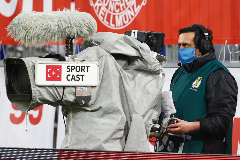 A TV camera operator wears a protective face mask. EPA