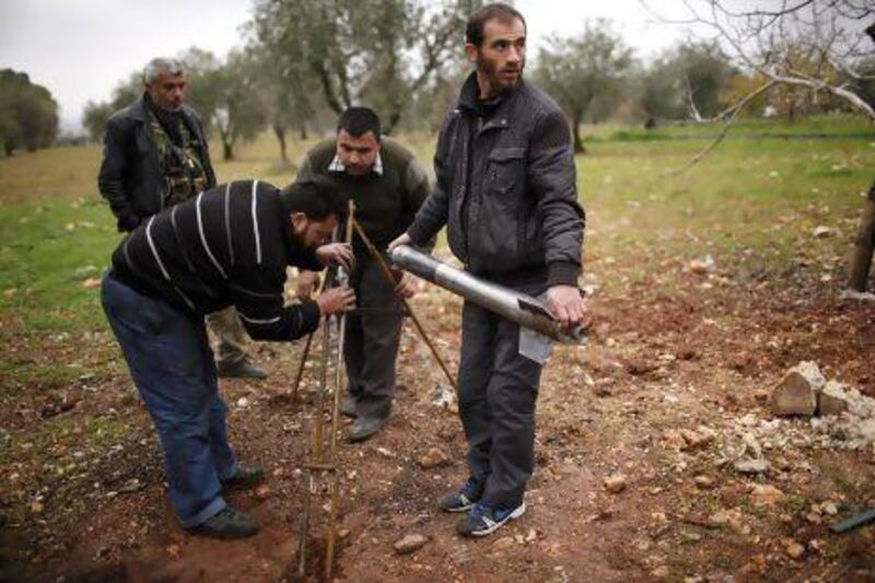 Free Syrian Army fighters prepare a homemade missile before they launch it towards the military airport in Aleppo.