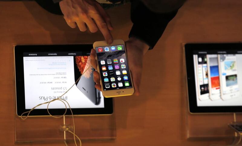 A customer in an Apple store checks the new iPhone 6 in Paris. Christophe Ena / AP Photo