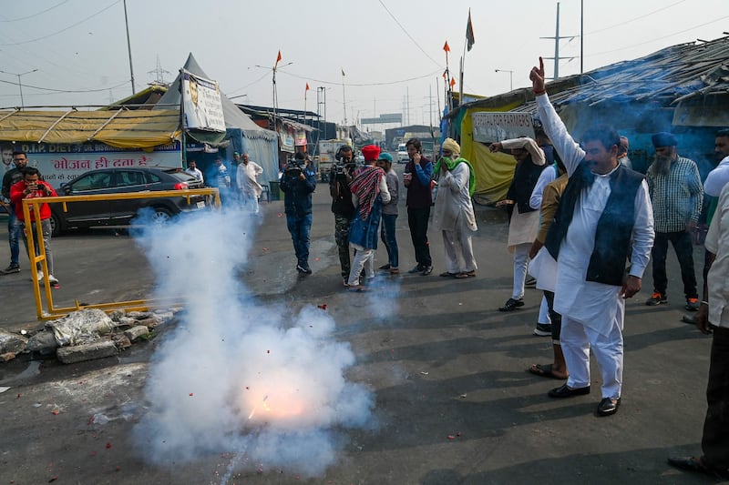 Farmers in Ghaziabad light firecrackers to celebrate. AFP