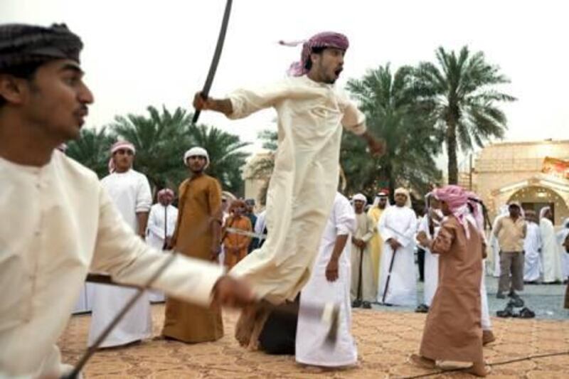 al Rams- April 17, 2009 - A young boy leaps into the air with his sword or Saif (CHECK SPELLING) during a mock battle with another boy during a traditional Arabic dance called the Razif at an Emirati wedding celebration for two grooms of the Shehhi tribe in the village of al Mahboobi in al Rams near Ras al Khaimah April 17, 2009.  The blades have been dulled to help prevent serious injury if one makes contact with the blade. (Photo by Jeff Topping/The National) *** Local Caption ***  JT013-0417-EMIRATI WEDDING IMG_6836.jpgJT013-0417-EMIRATI WEDDING IMG_6836.jpg
