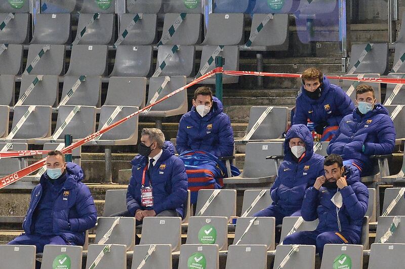 Barcelona's Lionel Messi, centre, sits with substitutes during the match. AFP