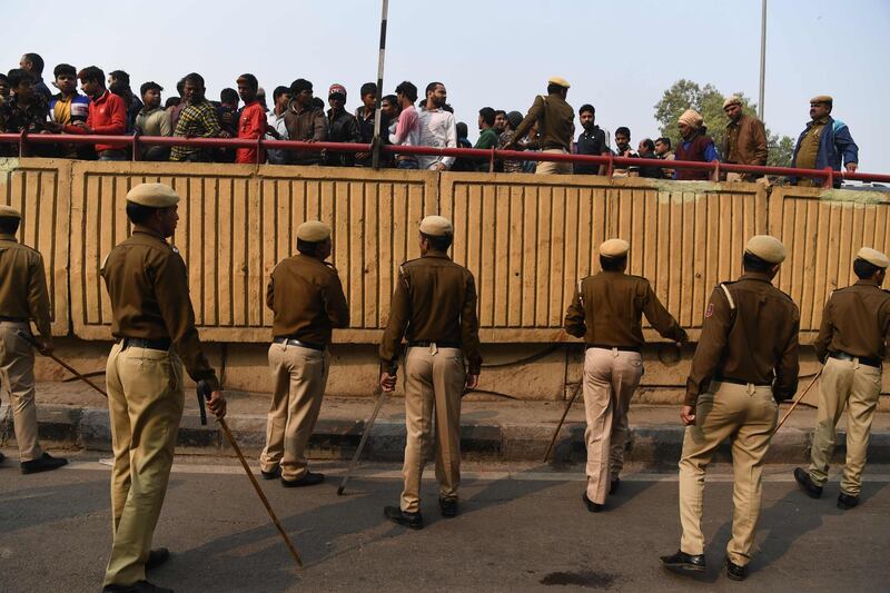 Police personnel move onlookers from a road after following a factory fire in Anaj Mandi area of New Delh.  At least 43 people have died in a factory fire in India's capital New Delhi, with the toll still expected to rise.  AFP