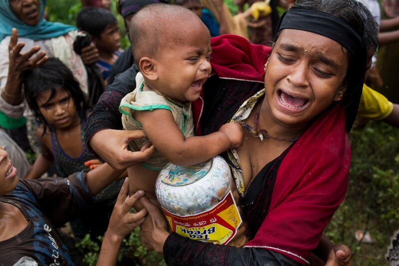 A Rohingya woman breaks down after a fight erupted during food distribution by local volunteers at Kutupalong, Bangladesh. The massive refugee camp in Kutupalong was set up in the early 90s to accommodate the first waves of Rohingya Muslim refugees who started escaping convulsions of violence and persecution in Myanmar. Bernat Armangue / AP Photo