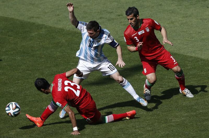 Iran defender Mehrdad Pooladi, left, and Argentina captain Lionel Messi vie for the ball during their 2014 World Cup Group F match on Saturday in Belo Horizonte, Brazil. Adrian Dennis / AFP
