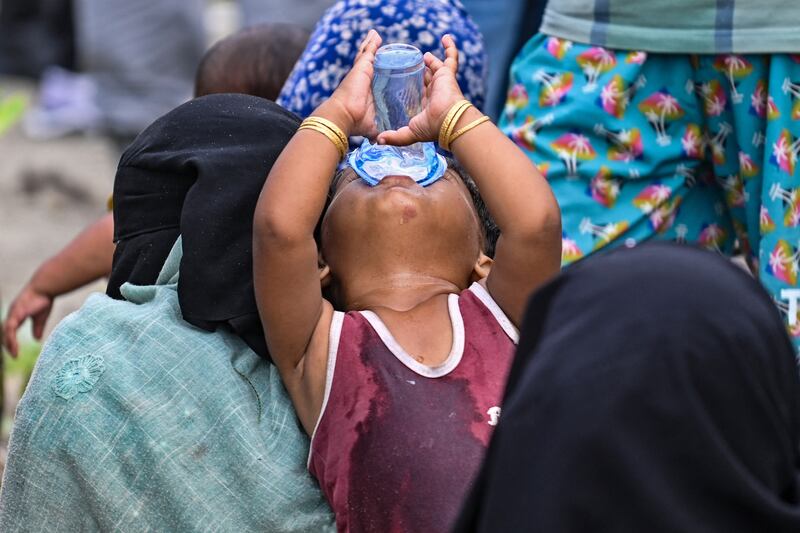 A child drinks after arriving by boat in Indonesia. Many Rohingya are fleeing refugee camps in Cox's Bazaar, Bangladesh, where kidnapping, rape and violence have become common. AFP