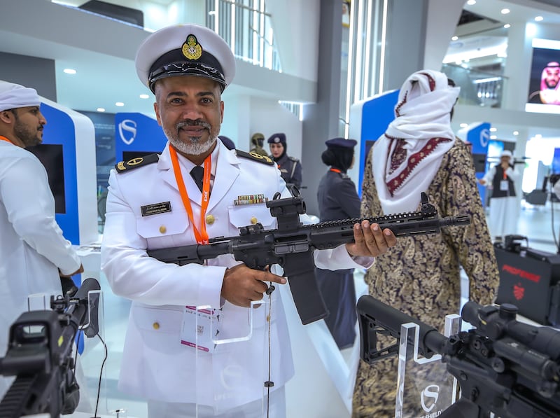 A UAE Navy officer picks up a firearm