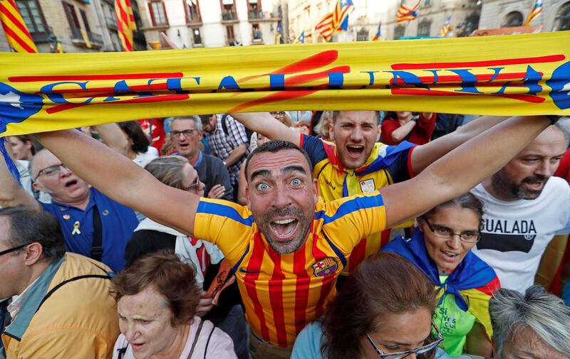 A man displays a scarf featuring an Estelada (Catalan separatist flag) design, as he reacts at Sant Jaume Square after the Catalan regional parliament declares independence from Spain. Yves Herman / Reuters