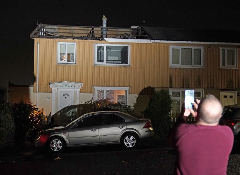 A homeowner, who lost the roof of his house in strong winds, takes a picture of his property in Blackhall, County Durham. Photo: PA