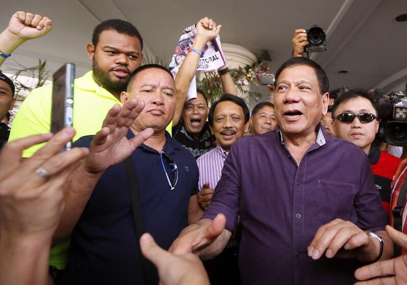 Rodrigo Duterte, right, in November last year after he was made the PDP-Laban party’s standard-bearer for presidential elections in May.  His political rise has been likened to that of US billionaire Donald Trump, but Mr Duterte finds the comparison offensive. Bullit Marquez / AP Photo