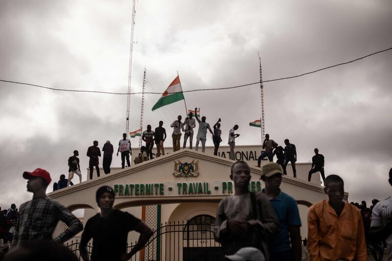 Pro-coup protesters hold a Niger flag during a demonstration against international sanctions on independence day in Niamey on August 3. AFP