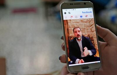 A woman watches the Facebook video of Syrian businessman Rami Makhlouf on her mobile in Syria's capital Damascus, on May 11, 2020. - Syria's top tycoon publicly airing his grievances has revealed a power struggle within the ruling family as it tries to cement its power after nine years of war, analysts say. After years of staying out of the limelight, business magnate Rami Makhlouf this month in two videos on Facebook laid bare his struggles with the regime headed by his first cousin President Bashar al-Assad, in what analysts say is a desperate last stand. (Photo by - / AFP)