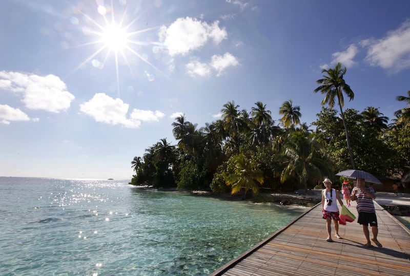 Tourists walk to a boat at a resort island at the Male Atoll . The very wealthy are increasingly block-booking whole resorts to throw parties. Reinhard Krause / Reuters