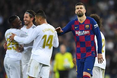 Gerard Pique of FC Barcelona acknowledges his supporters as Real Madrid CF players celebrate following their victory during the Liga match between Real Madrid CF and FC Barcelona at Estadio Santiago Bernabeu on March 01, 2020 in Madrid, Spain. Getty Images