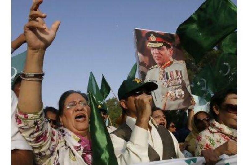 Supporters of the Pakistan Muslim League holding a picture of army chief General Ashfaq Parvez Kayani in Karachi. Shakil Adil / AP Photo