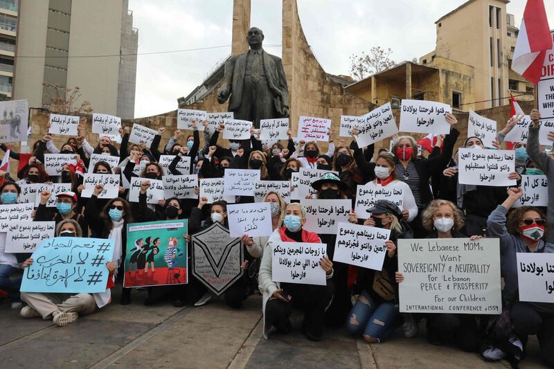 Lebanese women hold placards as they protest against the country's political paralysis and deep economic crisis in Beirut on the occasion of Mother's Day. AFP