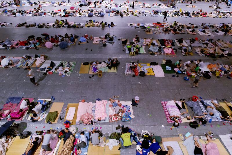 Migrant workers and their families rest after their workplaces in Hangzhou in eastern China's Zhejiang province were evacuated.