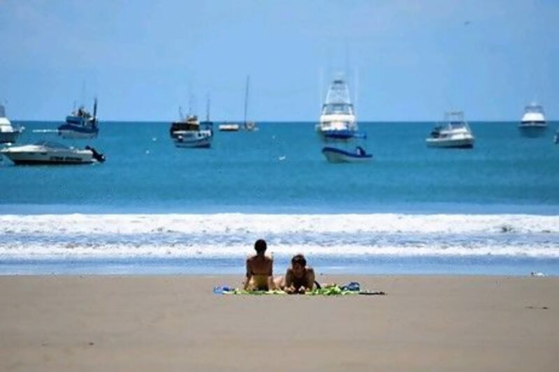 Tourists sunbathe on San Juan del Sur beach, 140km from Managua. Costa Rica ranks near the top of the happiness league. Hector Retamal / AFP