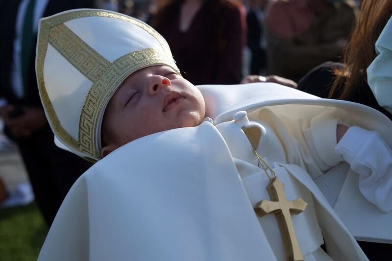 A baby dressed in papal outfit during a mass with Pope Francis at the Erbil Stadium. EPA