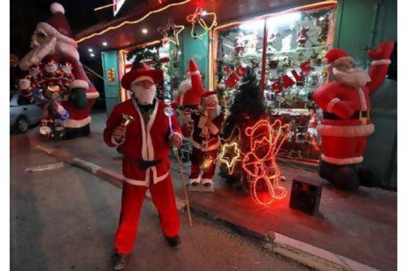 A vendor in Santa Claus outfit tries to attract customers outside a toyshop in the West Bank city of Bethlehem.