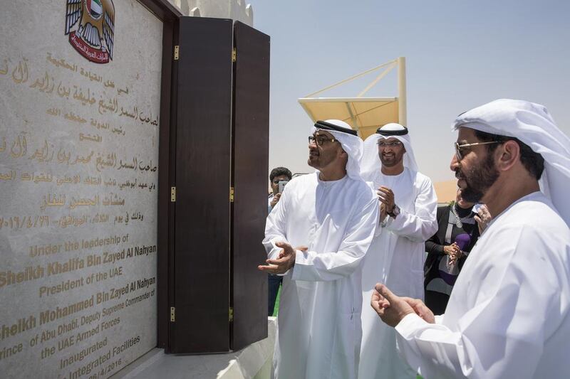 Sheikh Mohammed bin Zayed, left, Crown Prince of Abu Dhabi and Deputy Supreme Commander of the UAE Armed Forces, Sultan Al Jaber, centre, chief executive of Adnoc, and Sheikh Hamdan bin Zayed, the Ruler’s Representative in the Western Region, unveil a commemorative plaque during the inauguration of the Al Hosn facility. Ryan Carter / Crown Prince Court - Abu Dhabi
