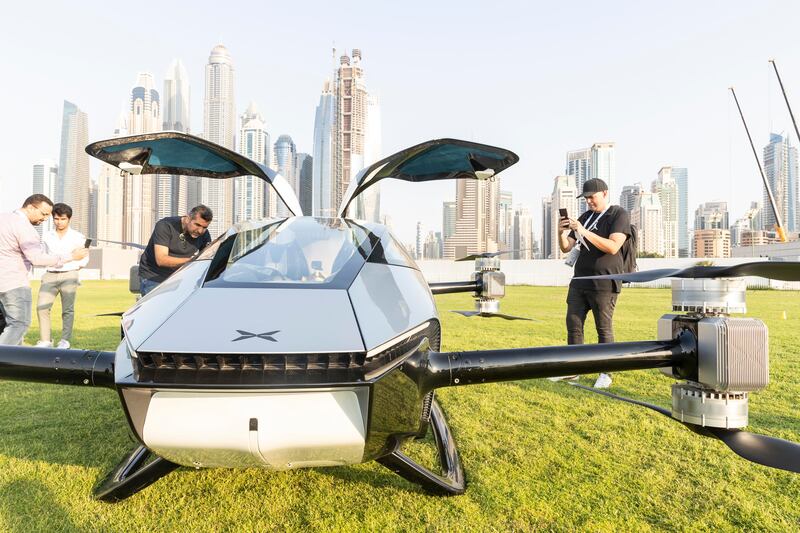 People take pictures of the flying car in Dubai Marina.