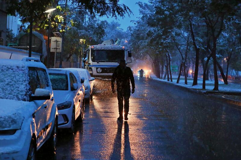 A man walks on a road while it snows in Baghdad, Iraq. AP Photo