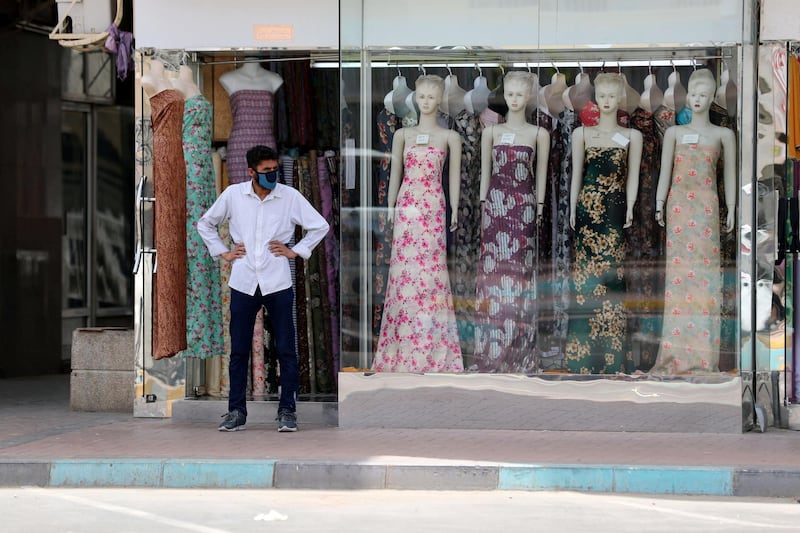 Al Ain, United Arab Emirates - Reporter: N/A: A shopkeeper wearing a facemask waits outside his dress store in Al Ain. Thursday, April 9th, 2020. Al Ain. Chris Whiteoak / The National