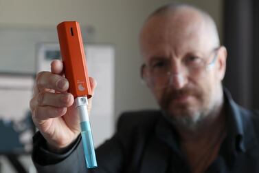  Allan Gaertke, chief executive and founder of Mondialab Pro holds up a device that can test for viruses like Covid-19 in just 10 minutes. Pawan Singh / The National