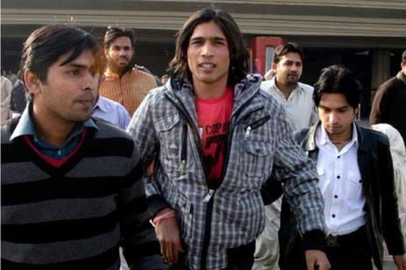 Mohammad Aamer, centre, is flanked by supporters as he arrives from Doha in this file photo after the hearing last month.