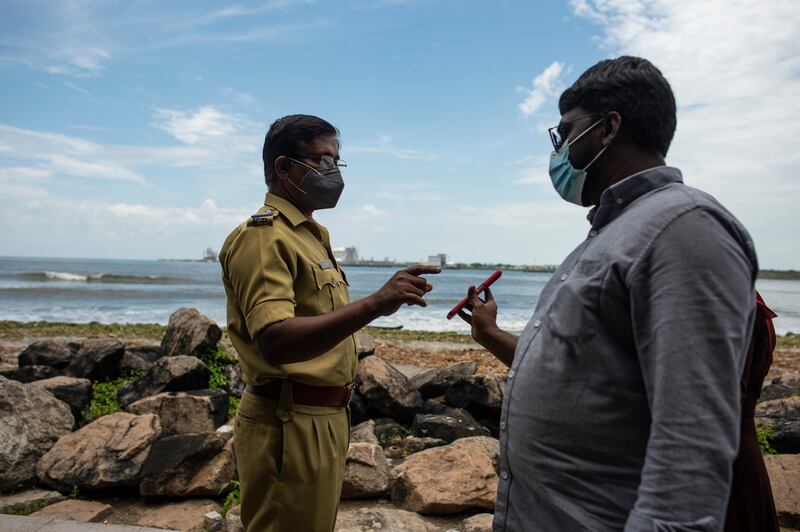 A man shows his Covid-19 vaccination certificate to a police officer as he visits Fort Kochi beach on the Arabian Sea coast in Kochi, Kerala state, India.  AP