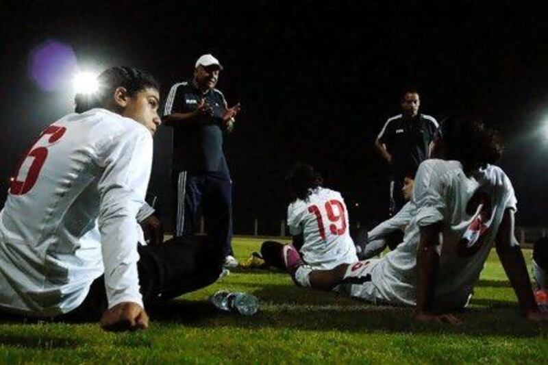 Omina Mahmoud, left and her Egyptian national teammates listen to coach Takrek El Siyagy during a practice game against a boys' team outside of Cairo, prior to a match against Jordan. John Perkins