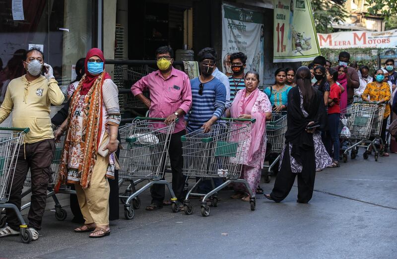 Indian people cover their faces as a precaution against the ongoing pandemic of the Covid-19 disease, stand in queue to buy groceries at a D-mart mall in Mira road on the outskirts of Mumbai, India.  EPA