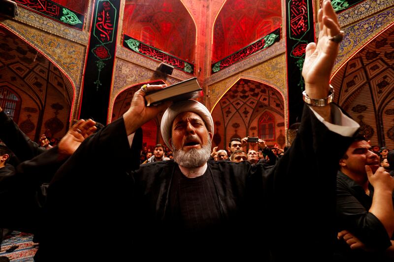 A Shiite cleric places a copy of the Quran on his head during commemorations of the death of Imam Ali during Ramadan at the shrine of Imam Ali in Najaf, Iraq. Reuters