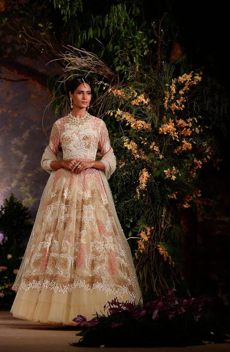 A floor-grazing anarkalis by Reynu Taandon combines a light-weight fabric and lace with intricate embroidery. AFP
