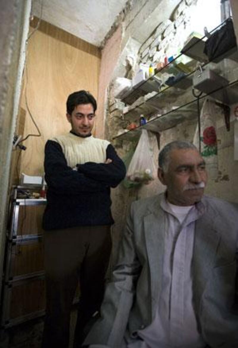 Salah Mehdi Mohammed, left, runs an unlicensed clinic in Aziziyah. Although Mr Mohammed is not a trained doctor or pharmacist, hundreds of the city's poorer residents such as Abu Mohammed, right, go to him for treatment rather than the more expensive and over-stretched state-run medical system.