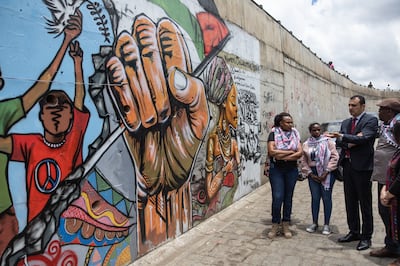 Palestinian Ambassador to Kenya Hazem Shabat (2nd-R) pose next to a mural in support of the Palestinian people on a bridge along the Outer Ring Road in Nairobi. Photo: AFP
