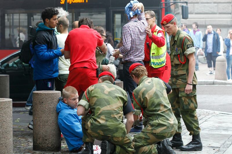 Wounded people are treated in the street in the centre of Oslo, Friday July 22, 2011, following an explosion that tore open several buildings including the prime minister's office, shattering windows and covering the street with documents and debris. (AP Photo/Scanpix, Berit Roald) *** Local Caption ***  Norway Explosion.JPEG-0a08d.jpg