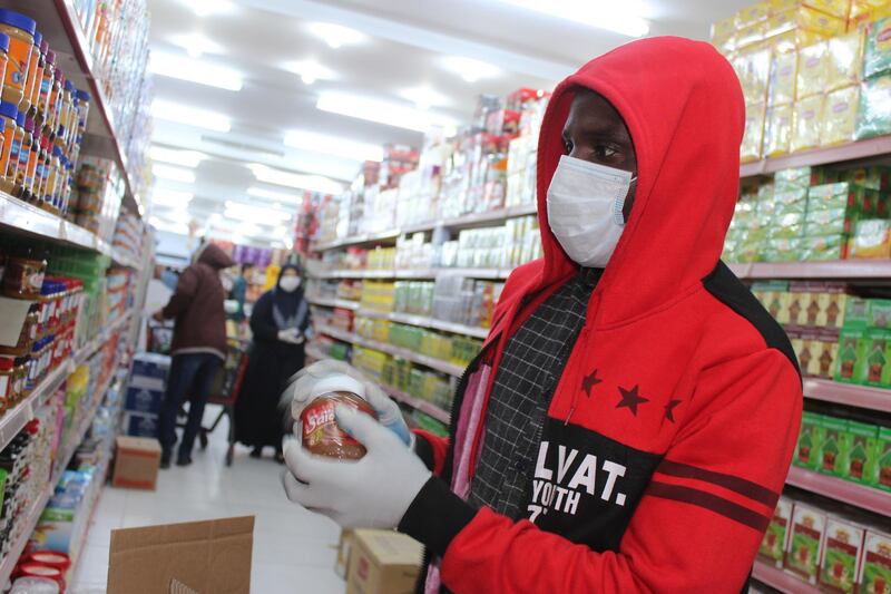 A worker fills the shelves at a supermarket before the curfew in Misrata, Libya. Reuters