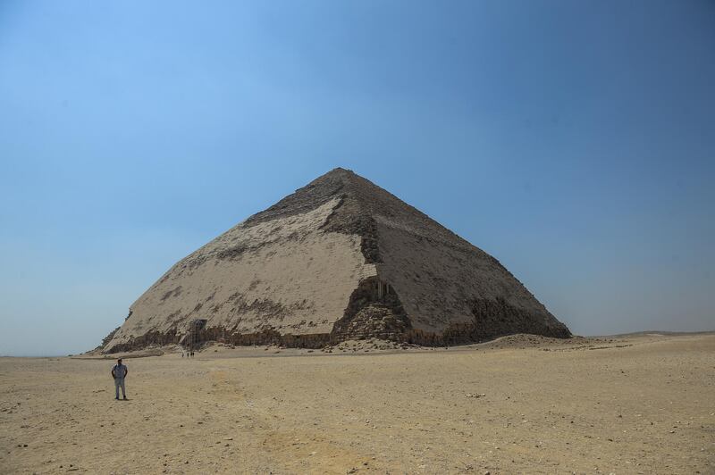A picture taken on July 13, 2019 shows the Bent pyramid of King Sneferu, the first pharaoh of Egypt's 4th dynasty, in the ancient royal necropolis of Dahshur on the west bank of the Nile River, south of the capital Cairo. - An Egyptian archaeological mission discovered a collection of stone, clay and wooden sarcophagi, of which some are still containing well preserved mummies, as well as a collection of wooden funerary masks and instruments used in cutting stones . (Photo by Mohamed el-Shahed / AFP)