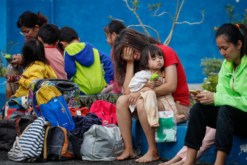 Survivors rest at a police station after a landslide hit a tourist campground in Batang Kali, Malaysia, killing at least 16 people.   EPA 