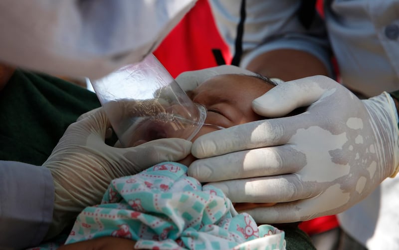 A ten-month old baby girl survivor, Refi, is aided by volunteers doctors at an emergency hospital in Tanjung.   EPA