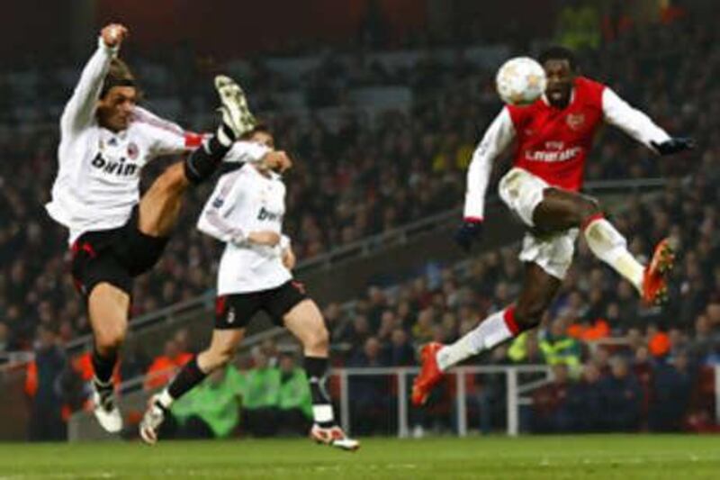 Paolo Maldini, left, challenges Arsenal's Emmanuel Adebayor in the Champions League.