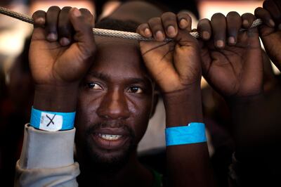 FILE - In this June 17, 2017 file photo, Samuel, 25, from Nigeria, waits his turn to leave the Golfo Azzurro rescue vessel, after being rescued from a packed boat from Libya, by members of Proactive Open Arms, as they arrive at the port of Pozzallo, south of Sicily, Italy. Under a deal backed by Italy, Libya��������s struggling government in Tripoli has paid militias that were once involved in smuggling migrants to now prevent migrants from crossing the Mediterranean to Europe, one reason for a dramatic drop in the traffic, according to militia and security officials. (AP Photo/Emilio Morenatti, File)