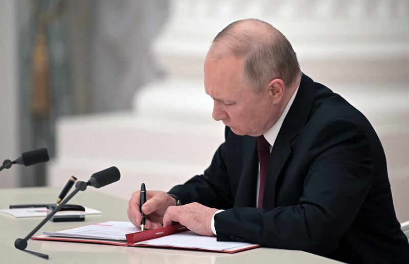 Russian President Vladimir Putin signs documents, including a decree recognising two Russian-backed breakaway regions in eastern Ukraine as independent, during a ceremony at the Kremlin in Moscow.  President Vladimir Putin said on February 21, 2022, he would make a decision "today" on recognising the independence of east Ukraine's rebel republics, after Russia's top officials made impassioned speeches in favour of the move. AFP
