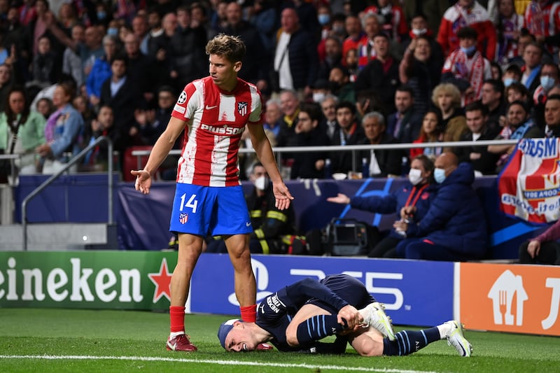 Phil Foden goes down injured watched by Marcos Llorente. Getty