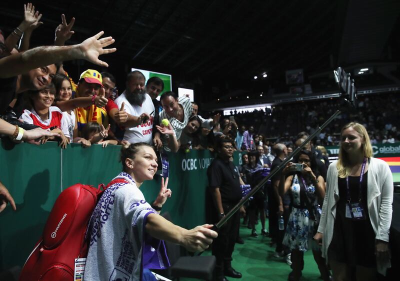 SINGAPORE - OCTOBER 23:  Simona Halep of Romania takes a selfie with fans after her singles match against Caroline Garcia of France during day 2 of the BNP Paribas WTA Finals Singapore presented by SC Global at Singapore Sports Hub on October 23, 2017 in Singapore.  (Photo by Julian Finney/Getty Images for WTA)