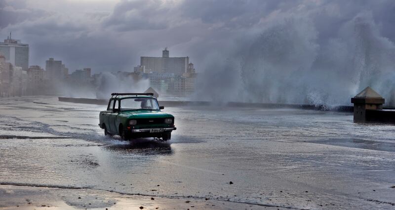 A car passes through an area of the boardwalk hit by strong waves in Havana, Cuba.  The Cuban Institute of Meteorology (Insmet) recorded strong gusts of wind of up to 104 kilometers per hour and strong waves in the west of the island due to a cold front associated with an 'extratropical low. '  EPA
